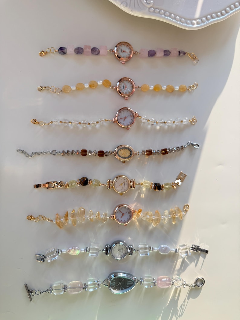 Pu&ograve; includere: Collezione di delicati orologi da polso con vari braccialetti di pietre preziose e perline. Gli orologi hanno quadranti rotondi o ovali con numeri romani. I braccialetti presentano quarzo rosa, citrino e perline di cristallo trasparente.