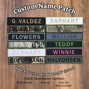 Puede incluir: Una colección de parches rectangulares personalizados con nombres en varios colores y patrones de camuflaje con texto bordado. Cada parche mide 12,5 cm de ancho y 2,5 cm de alto. El texto incluye nombres como G. VALDEZ, EARHART, FLOWERS, SCOLAVINO, BOECKMANN, NUMQUAM SATIS, MELLISS, TEDDY, WINNIE y HALVORSEN.