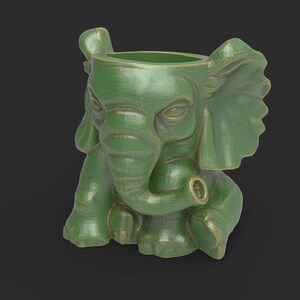 Może przedstawiać: Zielona ceramiczna donica w kształcie słonia z teksturowanym wykończeniem. Słoń ma duże uszy, trąbę zwiniętą do góry i szczegółową twarz. Donica jest przeznaczona do przechowywania roślin lub kwiatów.