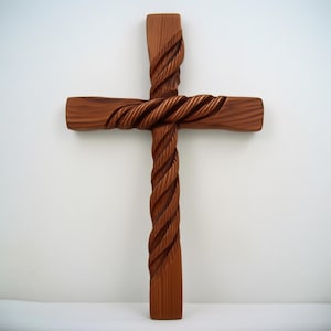 以下が含まれることがあります： 彫刻されたロープのデザインの木製の十字架。十字架は明るい茶色の木材でできており、テクスチャード加工された表面を持っています。ロープのデザインは、十字架の垂直および水平ビームの周りに巻き付いています。