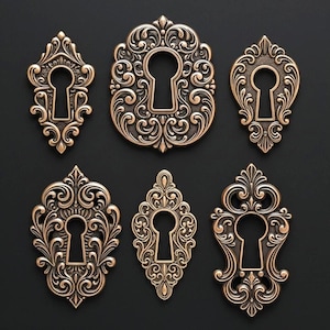 Puede incluir: Seis cubiertas de ojo de cerradura ornamentadas de estilo antiguo en varias formas. Las cubiertas de ojo de cerradura son de metal color bronce y presentan intrincados diseños de volutas y florales. Se disponen sobre un fondo negro.