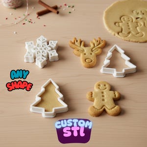 Könnte beinhalten: Eine Auswahl an Weihnachtsplätzchenausstechern und gebackenen Keksen in Formen wie Schneeflocke, Rentier, Weihnachtsbaum und Lebkuchenmann. Der Text "ANY SHAPE" und "CUSTOM STL" ist ebenfalls enthalten.