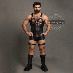 May include: Black leather romper with harness detailing, featuring a front zipper and attached shorts. The outfit includes leg straps with buckles and is paired with black platform boots. The image has the text "Keep it Simple, Live in the Moment" and "Leather Synergy".