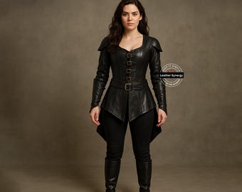 Op de afbeelding: Zwarte leren jas met een getailleerd lijfje, lange mouwen en een uitlopende peplum. De jas heeft meerdere gespen en een riem in de taille. Het model draagt een zwarte broek en laarzen. De tekst "Leather Synergy" is inbegrepen.