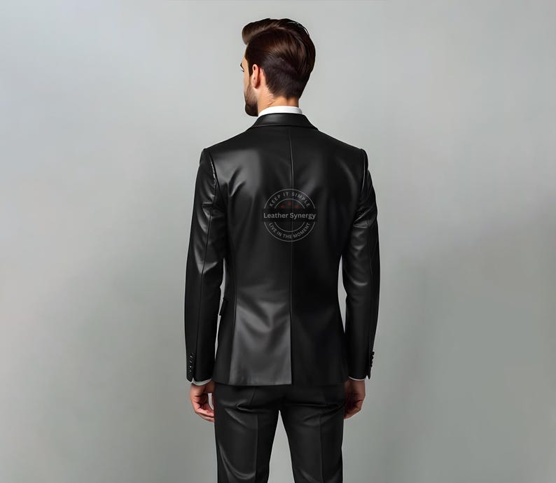 May include: A black leather blazer and matching pants. The blazer has a classic two-button design and notched lapels. The back of the blazer has a circular logo that reads "Leather Synergy" and "Keep it Simple, Live in the Moment."