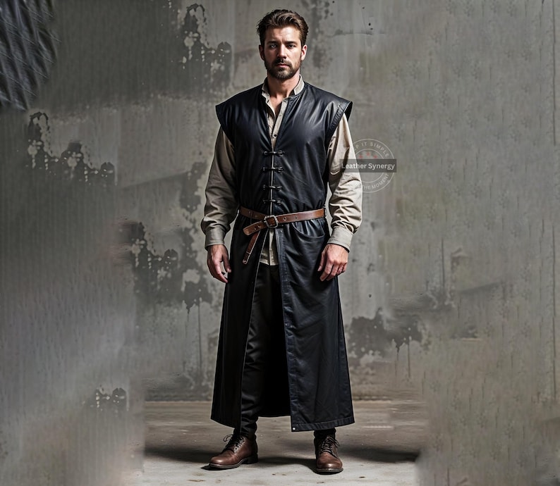 May include: A black leather vest with a long, flowing design, featuring a button-up front and a brown belt. The vest is worn over a light-colored shirt and dark pants. The outfit is completed with brown boots.