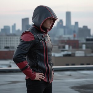 May include: Black leather jacket with a red trim and accents, featuring a hood. The jacket has red shoulder pads and cuffs, with a buckle closure and lace-up detailing on the side. The background shows a city skyline.