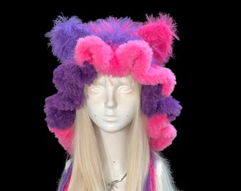 Capucha con orejas de gato de Cheshire en color morado y rosa: diseño suave, cálido y divertido.