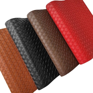 May include: A close-up of five sheets of woven leather in various colours. The colours include tan, black, brown, and red. The leather has a basketweave pattern, and the sheets are slightly overlapping.