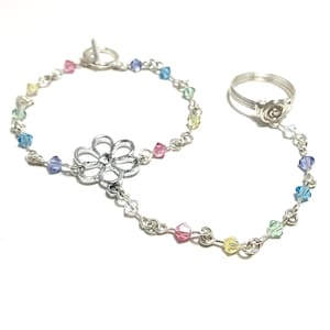 May include: A silver chain bracelet with a flower charm and a matching ring. The bracelet has a silver toggle clasp and is decorated with colorful crystal beads.