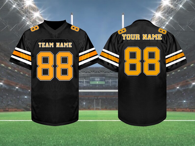 May include: Black football jersey with orange and white accents. The jersey features the number "88" in orange on the front and back, along with "TEAM NAME" and "YOUR NAME" in gold lettering. The jersey is displayed on a green field.