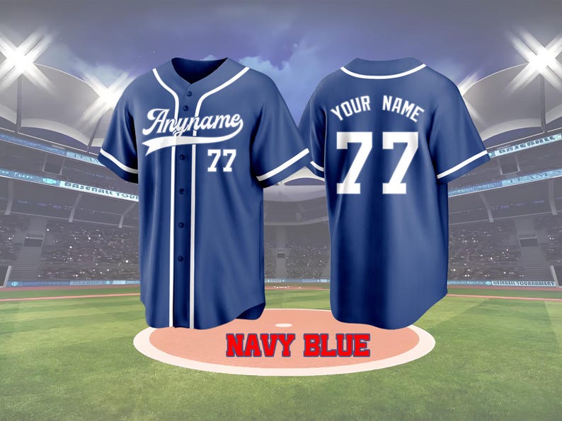 May include: Navy blue baseball jersey with white accents. The front features the name "Anyname" and the number 77. The back displays "YOUR NAME" and the number 77. The jersey is displayed on a baseball field.