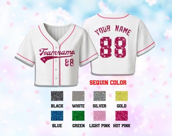 May include: White baseball jersey with pink trim and the text "Teamname" and the number "88" in a glittery pink font. The back of the jersey has "YOUR NAME" and "88". Color options include black, white, silver, gold, blue, green, light pink, and hot pink.