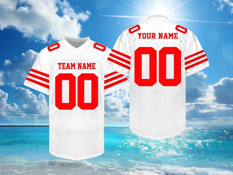 May include: White football jersey with red accents, including the number "00" on the front and back. The front displays "TEAM NAME" and the back says "YOUR NAME". The jersey has red stripes on the sleeves.