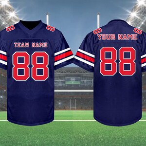 May include: Navy blue football jersey with red and white accents. The jersey features the number 88 in red on the front and back, with the text "TEAM NAME" and "YOUR NAME" above the numbers. The sleeves have red and white stripes.
