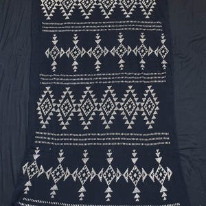 May include: A dark navy textile with a repeating geometric pattern in white. The design features diamond and triangle shapes arranged in horizontal bands. The fabric appears to be soft and draped.