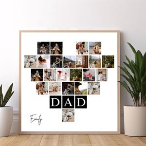 May include: A framed photo collage in a heart shape, filled with family photos. The word "DAD" is displayed in bold black letters, with the name "Emily" in cursive below. The frame is a light wood color.