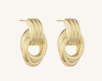 May include: A pair of gold-colored earrings. Each earring features a textured, oval-shaped design with a post for pierced ears. The earrings have a linked, chain-like appearance, with a polished finish.