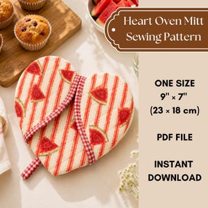 Peut inclure: Un patron de couture pour manique en forme de cœur avec un tissu crème à rayures rouges et motifs de tranches de pastèque. La manique présente un liseré à carreaux rouges et blancs et une boucle. Texte : Heart Oven Mitt Sewing Pattern, 23 cm x 18 cm.
