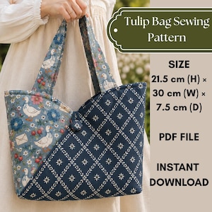 May include: A tulip bag sewing pattern PDF file featuring a dual-fabric design. One side displays a blue floral print with white geese and strawberries, while the other is a dark blue diamond lattice pattern. Dimensions are 21.5 cm H x 30 cm W x 7.5 cm D.