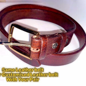 Pu&ograve; includere: Una cintura in pelle marrone scuro con fibbia color oro. La cintura &egrave; di un profondo color marrone rossiccio e sembra essere realizzata in pelle di alta qualit&agrave;. Il testo sull'immagine dice "Same Leather belt Order Customised Leather belt With Your Pair."