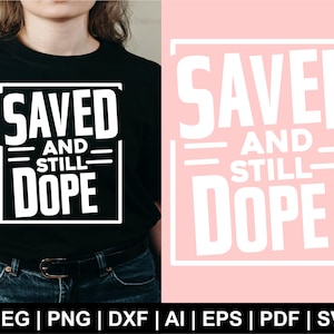 Puede incluir: Una camiseta negra con texto blanco que dice "SAVED AND STILL DOPE". El texto está en un rectángulo con un contorno blanco.