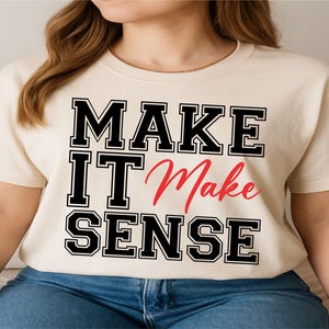 May include: Cream-colored t-shirt with the phrase "MAKE IT Make SENSE" in black block letters with a red cursive "Make". The shirt is made of a soft material and is suitable for casual wear.