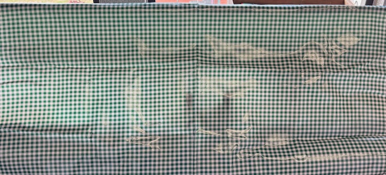 Puede incluir: Una tela a cuadros verde y blanca con un aspecto descolorido. La tela tiene una textura tejida y probablemente se utiliza para un mantel u otro art&iacute;culo para el hogar.