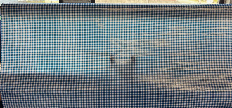 Puede incluir: Una tela de vichy azul y blanca con un patr&oacute;n a cuadros.