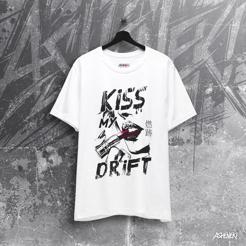 May include: White t-shirt with a black and white graphic print of a woman's lips with lipstick and the text "Kiss My Drift".