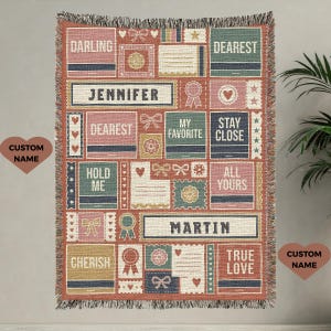 May include: Woven throw blanket with a patchwork design in shades of pink, green, and blue. The blanket features various text blocks with phrases like "Darling," "Dearest," and names, along with decorative elements like bows and hearts.