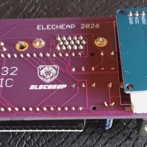Puede incluir: Una placa de circuito impreso ESP32 BASIC de color morado con el texto ELECHEAP 2026 y un logotipo de oso, que incluye un m&oacute;dulo adaptador de tarjeta Micro SD azul a la derecha, con pines met&aacute;licos, un conector blanco y un puerto circular.