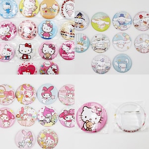 May include: A collection of Hello Kitty and My Melody character pinback buttons. The buttons are colorful and feature various designs, including Hello Kitty holding a teddy bear, My Melody with a bow, and Hello Kitty with a birthday cake. The buttons are packaged in clear plastic bags.