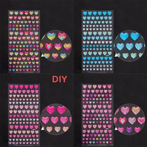 May include: Four sheets of iridescent heart-shaped stickers. Each sheet has a different color scheme: rainbow, blue, pink, and purple. The stickers are arranged in a grid pattern. The word "DIY" is printed in red letters on a white background.