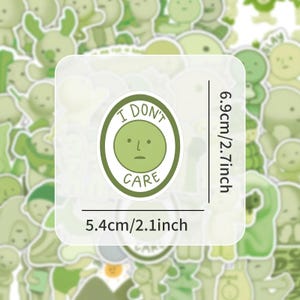 Peut inclure: Feuille d'autocollants verte et blanche avec une vari&eacute;t&eacute; de visages de dessins anim&eacute;s mignons. La feuille d'autocollants comprend un autocollant avec le texte "Je m'en fiche" et un visage de dessin anim&eacute; avec une moue. La feuille d'autocollants mesure 13,7 cm sur 17,5 cm.