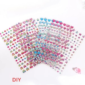 May include: A set of colorful, iridescent, adhesive sheets with hearts and stars. The sheets are transparent and have a glittery finish. The text "DIY" is printed on the bottom of the image.