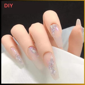 Puede incluir: Uñas postizas largas, transparentes, con purpurina plateada y detalles de perlas. Arte de uñas DIY.