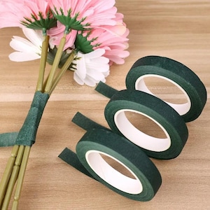 May include: Three rolls of green floral tape with white cores. The tape is used to secure stems and create a professional-looking bouquet.