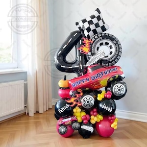 May include: A celebratory balloon display for a fourth birthday. The arrangement features a black number 4 balloon, a chequered flag, a tyre, and a red monster truck balloon with "HAPPY BIRTHDAY!". Additional balloons are in red, black, and yellow.