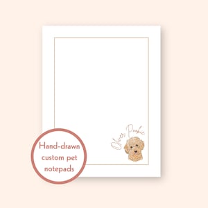 May include: A white notepad with a gold border and a hand-drawn illustration of a dog. The notepad has the text "Oliver Pookie" and "Hand-drawn custom pet notepads" in a circular design.
