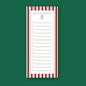 Peut inclure: Un bloc-notes rectangulaire avec un fond blanc et une liste de cases à cocher. Le bloc-notes a une bordure rayée dans les tons de rouge et de rose. Le haut du bloc-notes porte le texte "charmed & checked off" et un motif de nœud.
