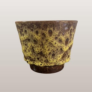 Op de afbeelding: Een set van drie keramische mokken met een gespikkelde, matte afwerking. De mokken zijn in tinten crème, lichtgrijs en donkergrijs. Elke mok heeft een eenvoudig, minimalistisch ontwerp, perfect voor koffie of thee.