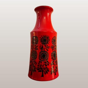 May include: A vibrant red ceramic vase with a flared base and a narrow neck. The vase features a repeating black floral pattern. It stands approximately 10 inches tall.