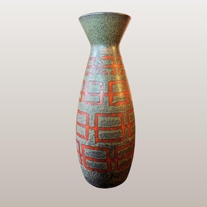 May include: A tall, ceramic vase with a flared top and a patterned design. The vase features a green top and a body with a repeating orange square pattern on a gray background. The text "WGP237 Carstens Tönnieshof 1223/40" is at the bottom.