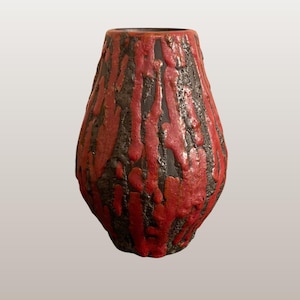 Può includere: Un vaso in ceramica rosso e nero con un design strutturato e gocciolante. Il vaso ha una base larga che si assottiglia verso un'apertura più stretta. Il testo "WGP287 Ceramano | 179 | Rubin" è in basso nell'immagine.
