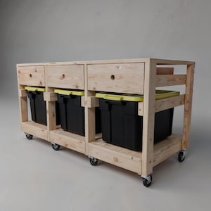 以下が含まれることがあります： 3つの引き出しと4つの収納ボックスが付いた木製収納カート。カートには車輪が付いており、天然木で作られています。