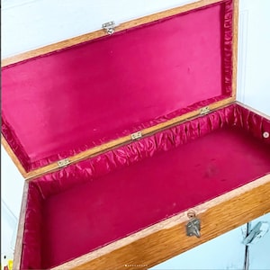 May include: An open wooden box with a red velvet lining. The box has a brass latch and hinges.
