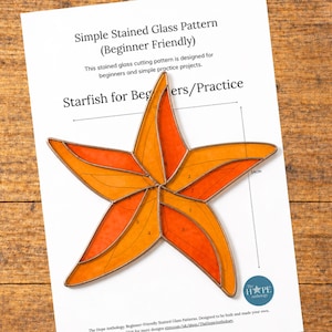 May include: A beginner-friendly stained glass pattern for a starfish, featuring orange and yellow glass segments. The pattern is printed on white paper and includes measurements. The image also shows tools and materials for glasswork.