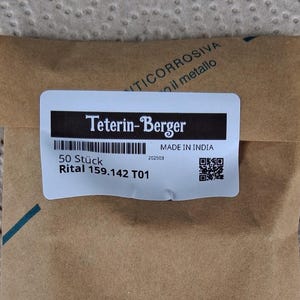 Puede incluir: Una etiqueta blanca con texto negro que dice "Teterin-Berger" y "MADE IN INDIA". La etiqueta también incluye un código de barras, un código QR y el texto "50 Stück Rital 159.142 T01 202503".