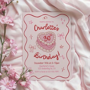 Puede incluir: Una invitación de cumpleaños rosa con detalles en rojo. La invitación dice "¡30 cumpleaños de Charlotte!" e incluye detalles del evento. Elementos decorativos incluyen estrellas, lazos y una ilustración de pastel en forma de corazón. La invitación está sobre un fondo de tela rosa.